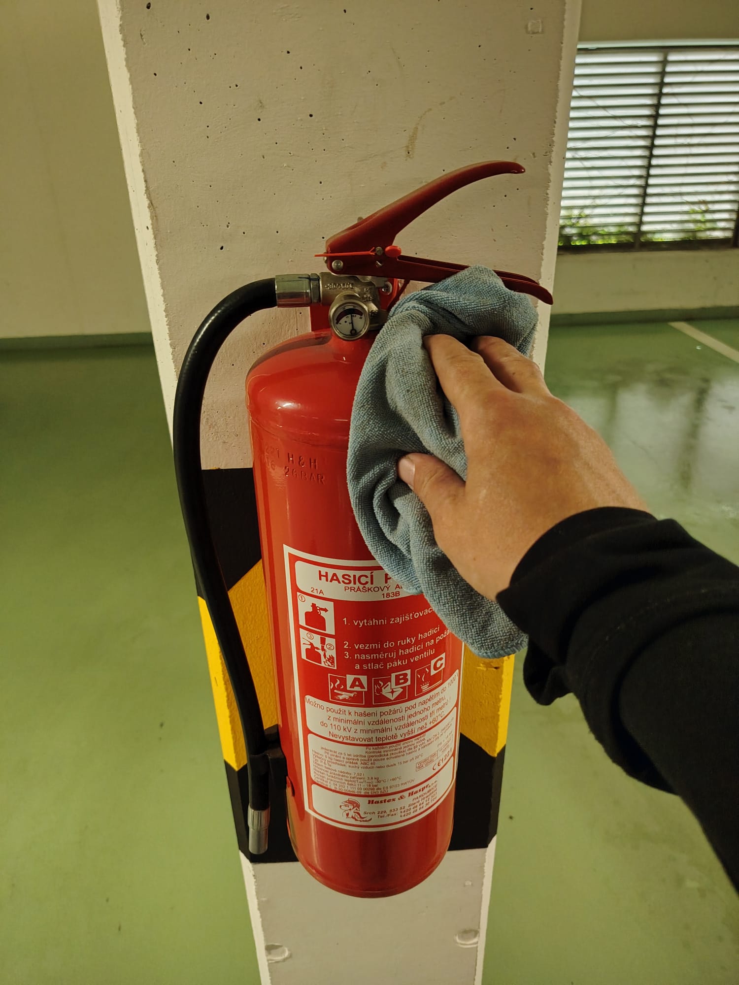 Ruční čištění hasicího přístroje v podzemní garáži