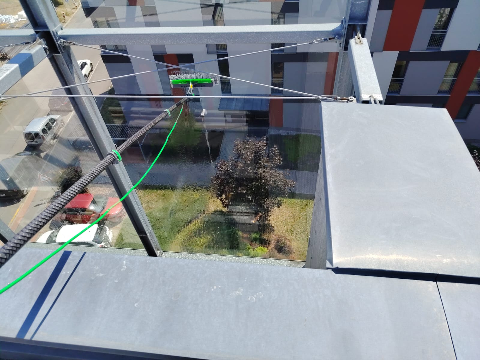 Detail mytí obtížně dostupné skleněné plochy